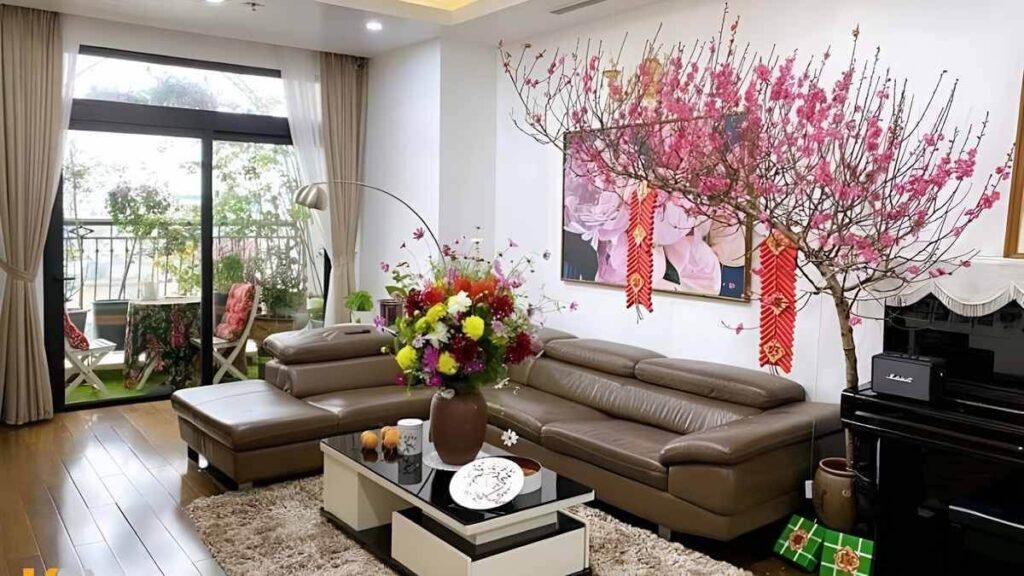 Trang trí phòng khách ngày Tết với đào hồng thắm và bàn sofa hiện đại, tạo không gian sáng, ấm cúng và sang trọng.